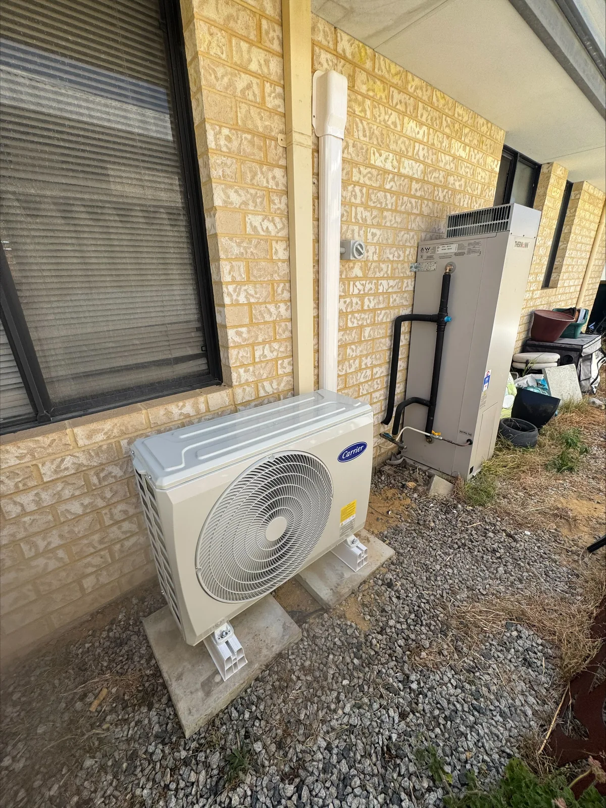 Air conditioning condenser and isolator installed on the side of a residential home