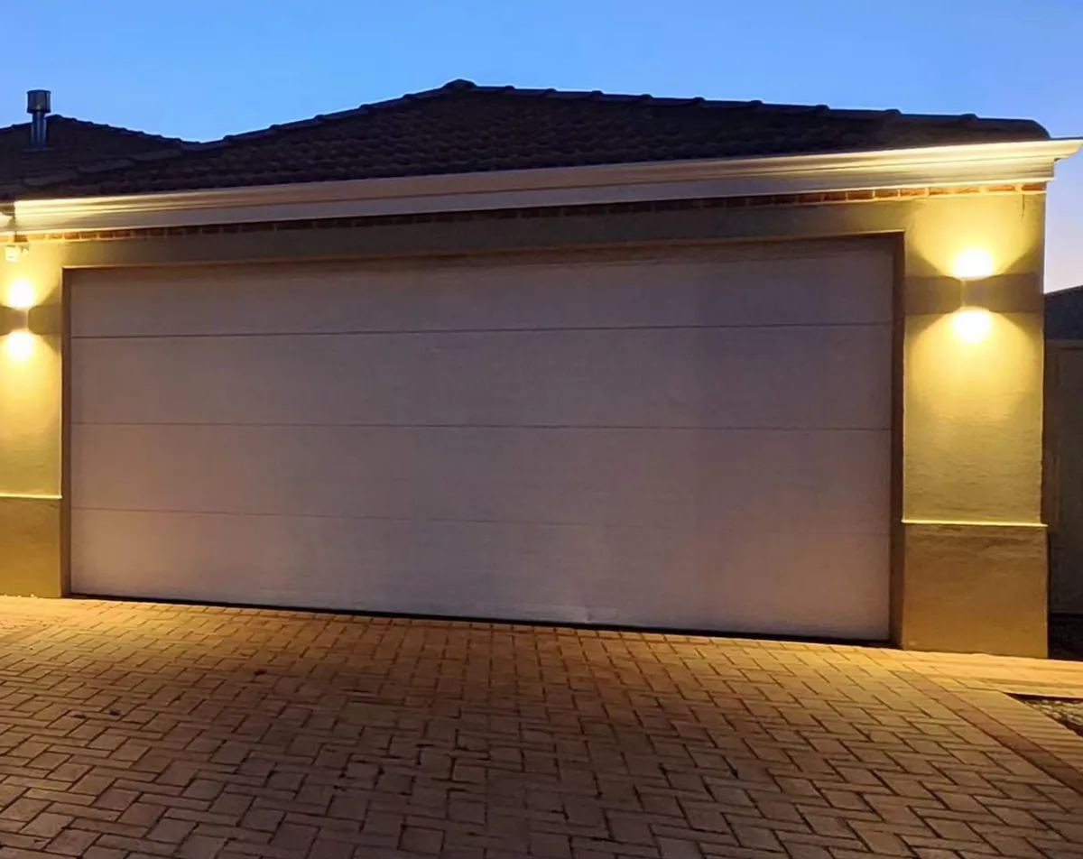 Garage and paved driveway of a home at dusk, the usual location for a home EV charger