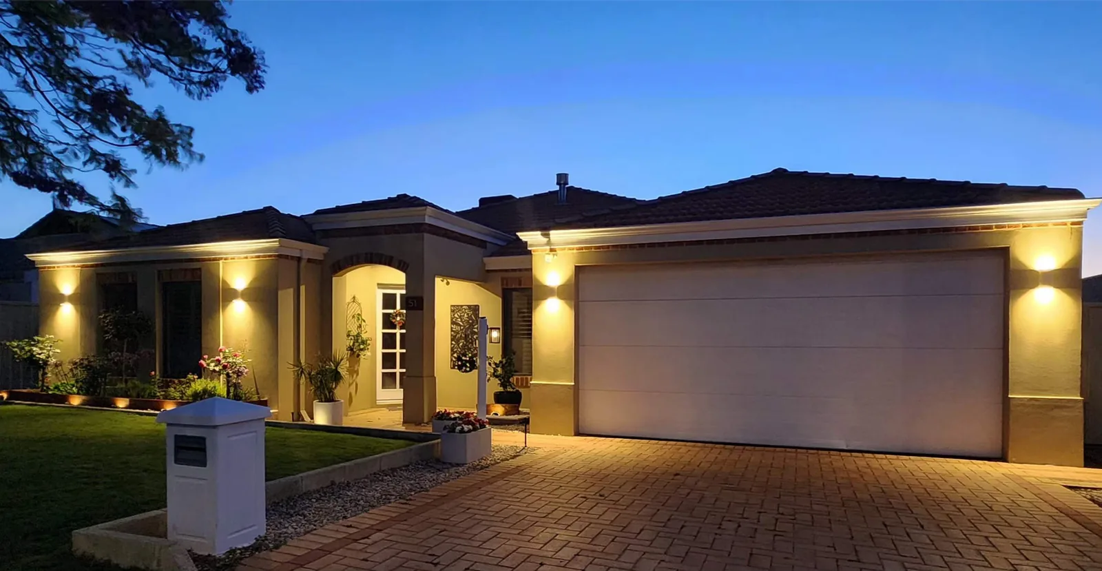 Full frontage of a Perth home at dusk with the eave, garden and entry lighting switched on