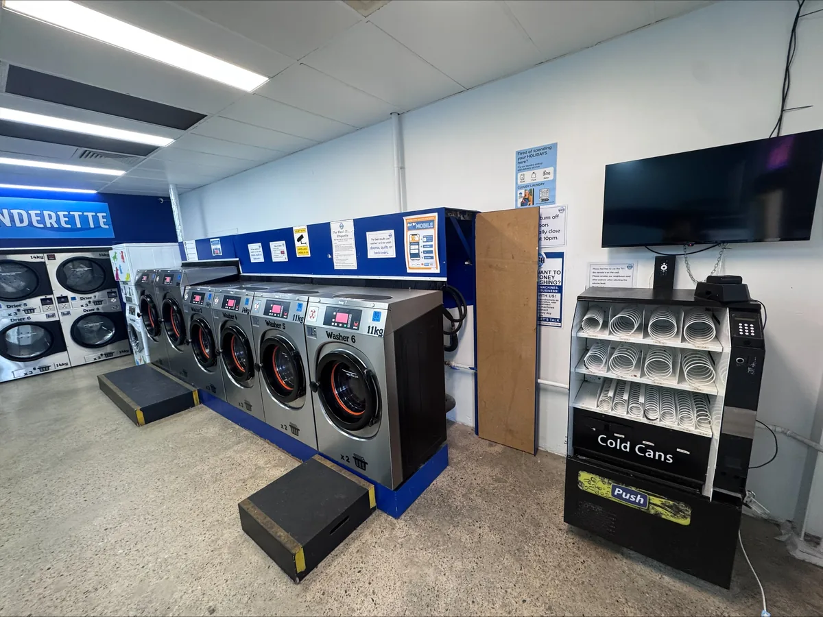 Commercial laundrette fitted out with washers, dryers, lighting, power and a wall-mounted display